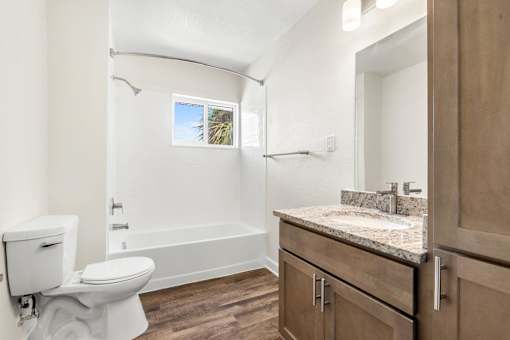 A bathroom with a toilet, sink, and bathtub.