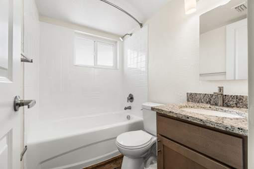 A white bathroom with a toilet, sink, and bathtub.