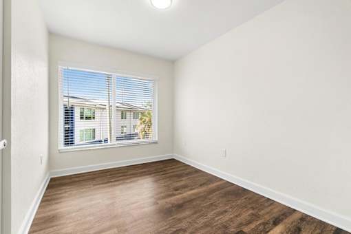 A room with a window overlooking a building.
