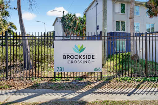 A sign that says Brookside Crossing 731 is on a black fence.