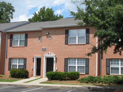 a brick house with a sidewalk in front of it