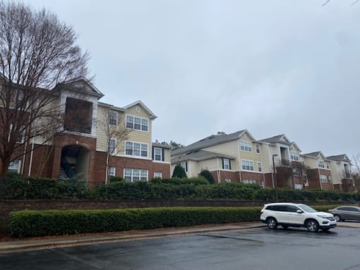 a white car parked in front of a row of houses