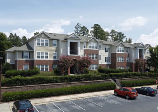 an apartment building with cars parked in a parking lot