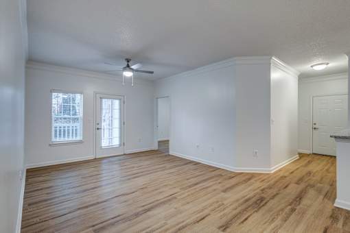 A room with wooden floors and a ceiling fan.