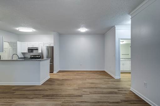 A kitchen with white cabinets and a wooden floor.