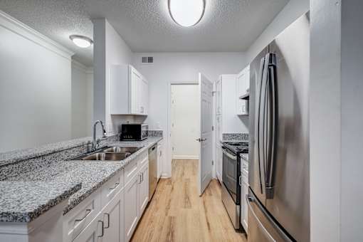 A kitchen with stainless steel appliances and granite countertops.