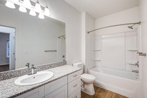 A white bathroom with a sink, toilet, and bathtub.