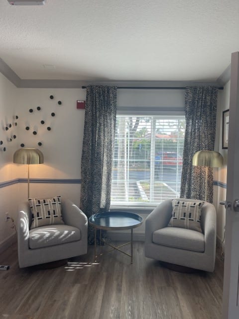 a bathroom with a window and a chair and a mirror