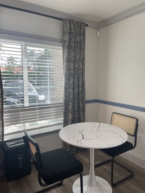 a living room with a window and a clock on the wall