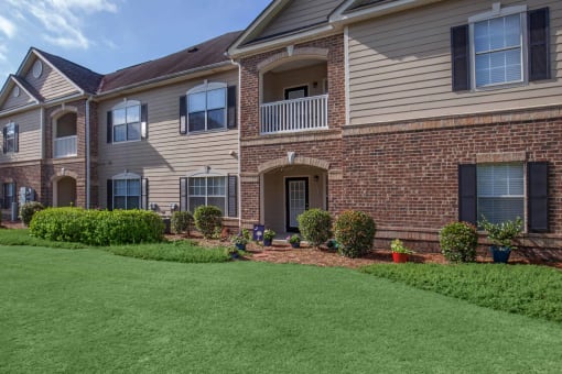 front view of an apartment building with green grass at Carrington Place at Wildewood, Columbia  