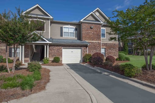 a large brick house with a white garage door in front of it at Carrington Place at Wildewood, Columbia, SC  