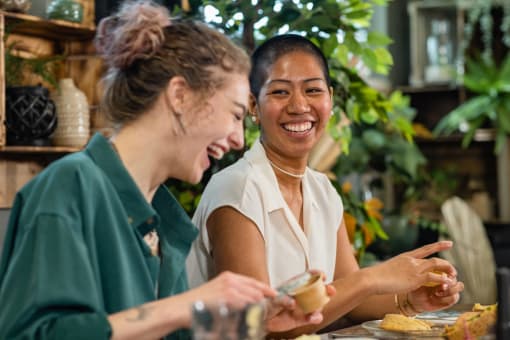 two women sitting at a table eating food