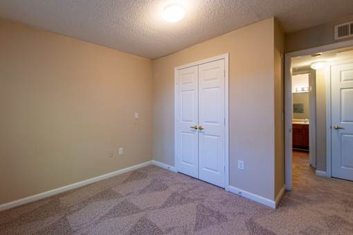 A room with a white door and carpeted floor at Lakeside Gardens Apartments, North Carolina, 27713