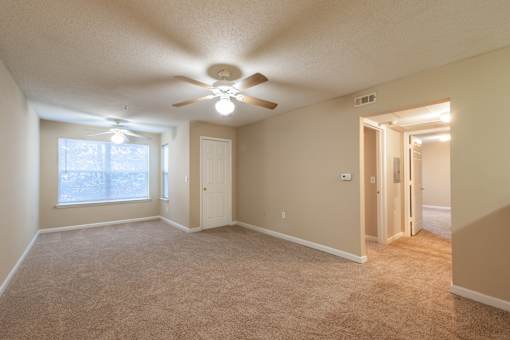 A room with a ceiling fan and carpeted floor at Lakeside Gardens Apartments, Durham, NC