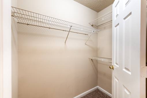 A white closet with a door and a shelf at Lakeside Gardens Apartments, Durham, North Carolina