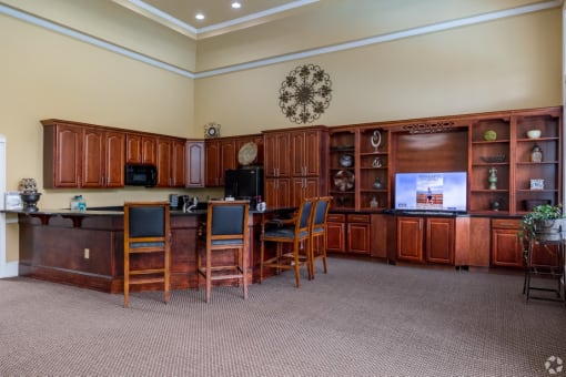 a break room with a table and chairs and a television at Magnolia Lake Apartments, Carrollton, GA, 30117