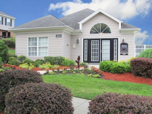 a small white house with a yard and a sidewalk