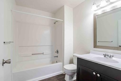 A white bathroom with a toilet, sink, and bathtub.