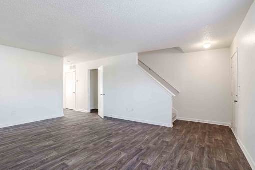 A room with a staircase and wood flooring.