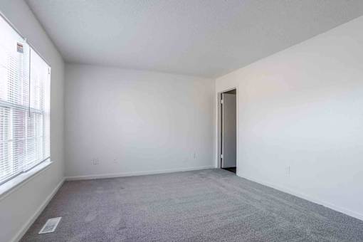 A room with a carpeted floor and a door.