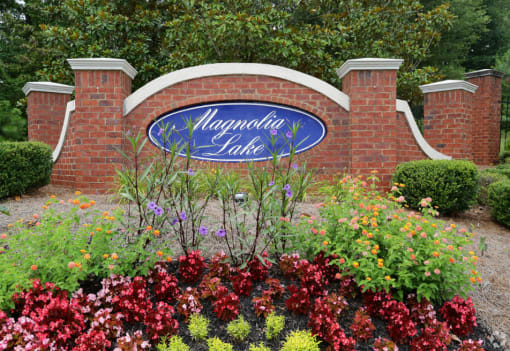the sign is in front of a brick garden at Magnolia Lake Apartments, Georgia 30117