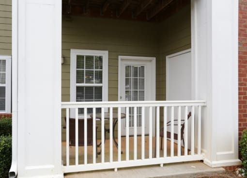 the front porch of a home with a white railing and a porch swing at Magnolia Lake Apartments, Carrollton, 30117
