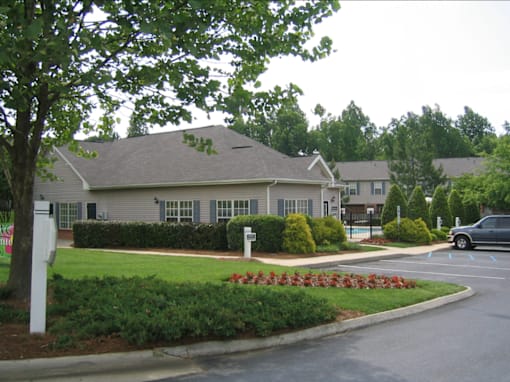 A grey house with a white mailbox in front of it.