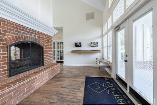 A brick fireplace is in a room with a blue rug on the floor.