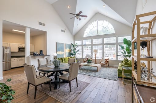A modern open plan living and dining room with a kitchen in the background.