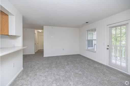 A room with white walls and a grey carpet.