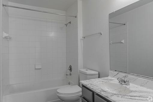 A white bathroom with a toilet, sink, and shower.