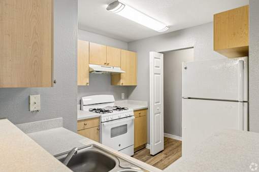 A kitchen with a white fridge, stove, and oven.