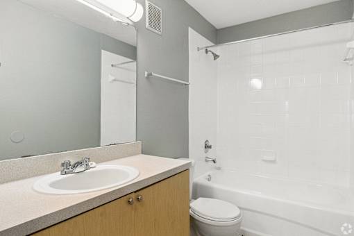 A bathroom with a toilet, sink, and bathtub.