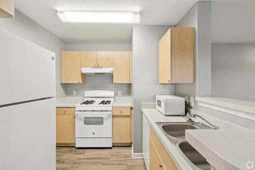A kitchen with a white refrigerator, white oven, and a white toaster.