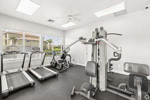 A gym with treadmills, a stationary bike, and a weight machine.