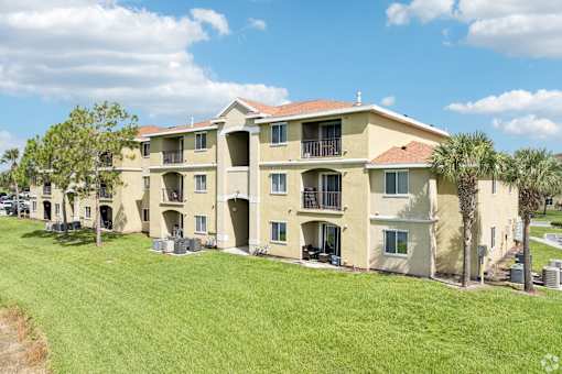 A large apartment complex with a green lawn in front.
