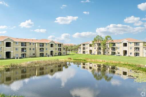 A row of houses are reflected in the water.