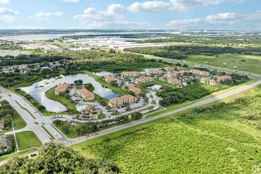 A bird's eye view of a residential area with a lake and greenery.