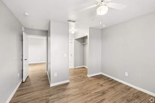 A room with a ceiling fan and wooden flooring.