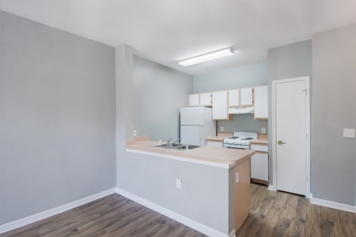 a kitchen with a white refrigerator freezer next to a white stove top oven