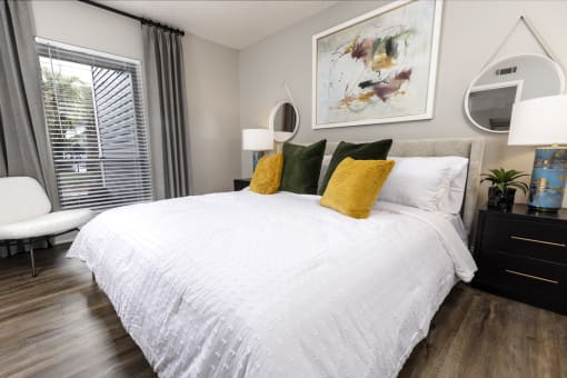 a bedroom with a large bed with white bedding and yellow and green pillows