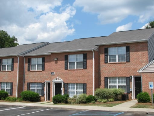 a brick apartment building with a sidewalk in front of it