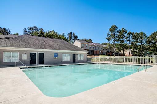 A swimming pool in front of a building with a blue sign.