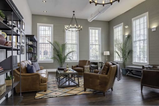 a living room with brown leather furniture and a chandelier
