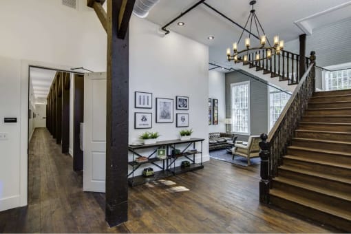 the entryway of a house with a staircase and a chandelier