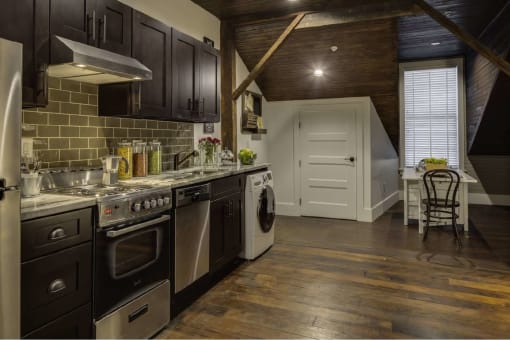 a kitchen with stainless steel appliances and a door to a dining room
