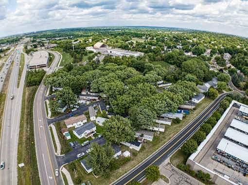 an aerial view of a city with trees and a highway