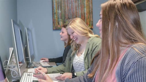 three women sitting at a desk working on computers at Boulder Ridge, Duluth, MN 55811