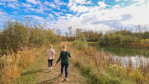 two women walking along a trail next to a lake at Boulder Ridge, Minnesota