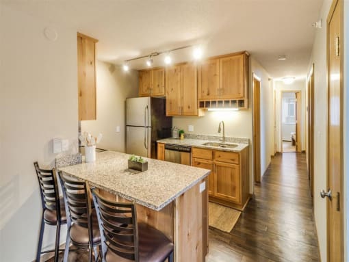 a kitchen with a marble counter top and wooden cabinets at Campus Park, Minnesota, 55811